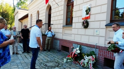 Kwiaty przed tablicą upamiętniającą Kornela Morawieckiego