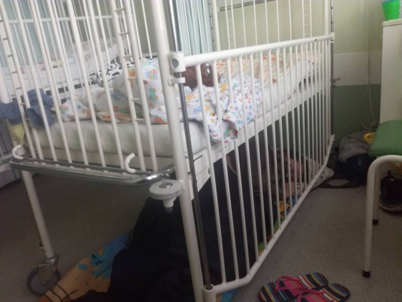 Kobieta śpiąca pod łóżeczkiem chorego dziecka leczonego w jeleniogórskim szpitalu - Zdjęcie pochodzi z Facebooka ojca dziecka