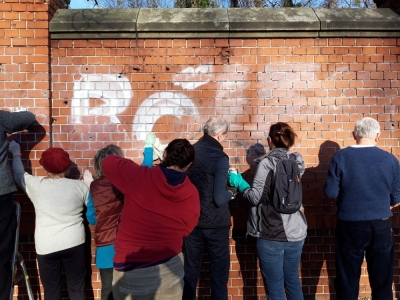 Wrocławianie usunęli graffiti z muru cmentarza [ZDJĘCIA]